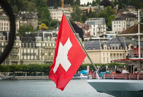 voilier rouge et blanc sur l'eau près des bâtiments de la ville pendant la journée