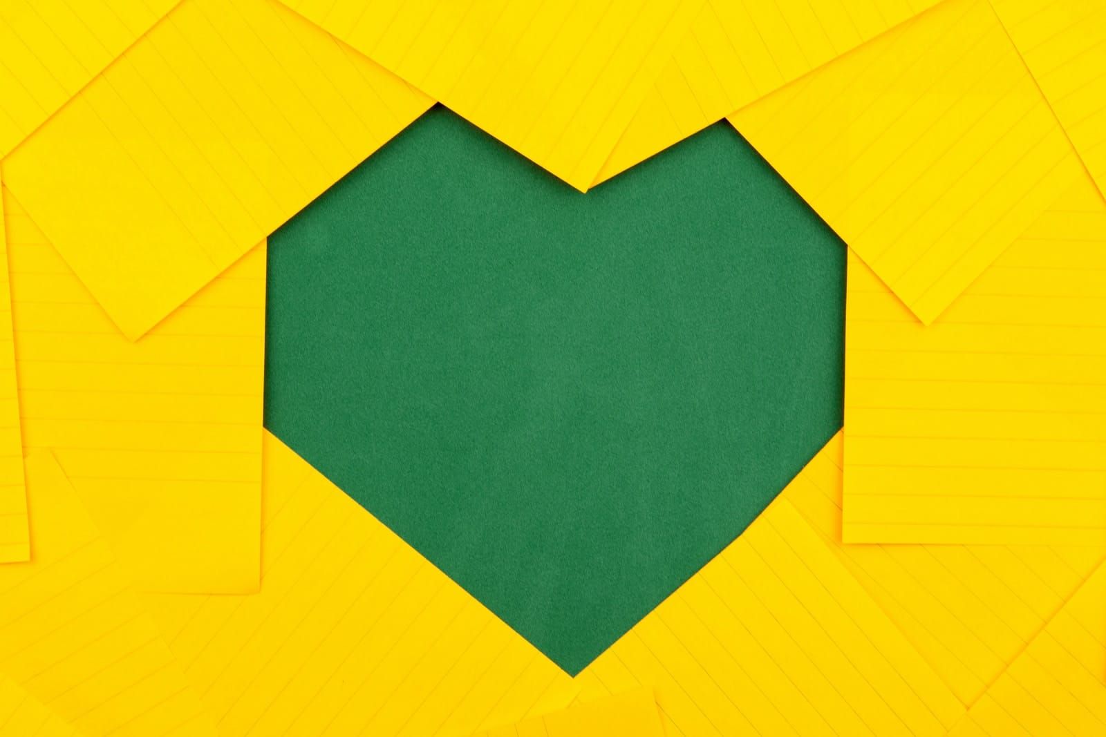 papéis amarelos formando um buraco de coração verde