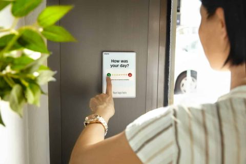 person holding white card near green plant