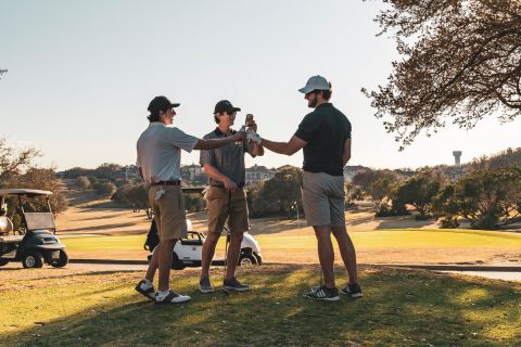 Homem de camiseta preta e bermuda marrom jogando golfe durante o dia