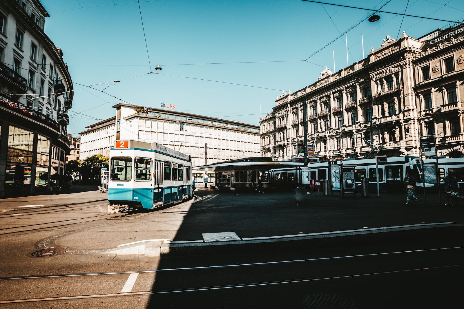 train at middle of street surrounded by buildings