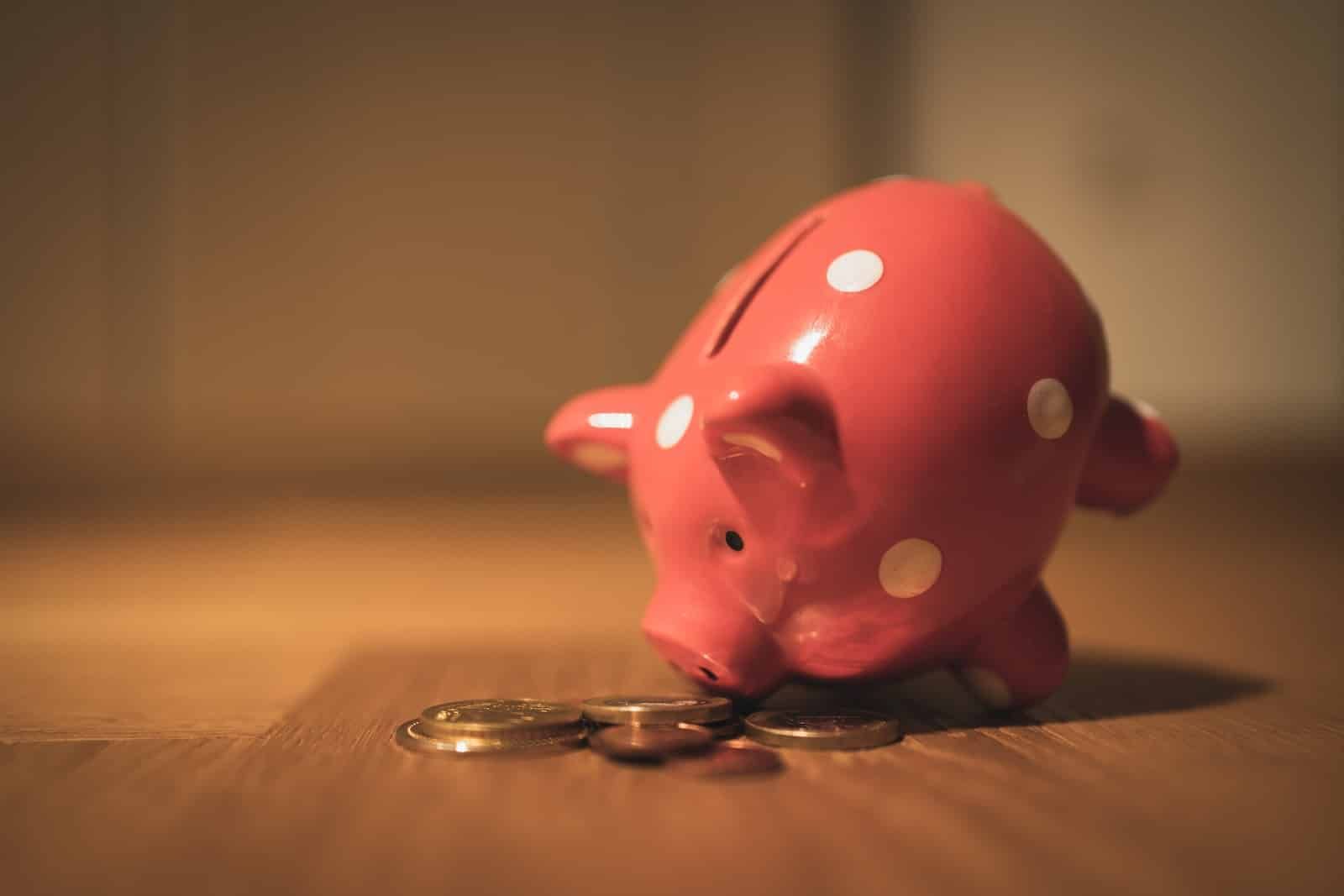 banque de pièces de monnaie en forme de cochon rose sur une table en bois marron