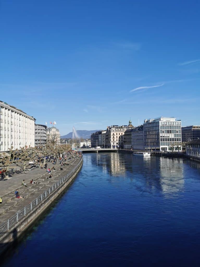 bâtiment en béton blanc et gris près d'un plan d'eau pendant la journée