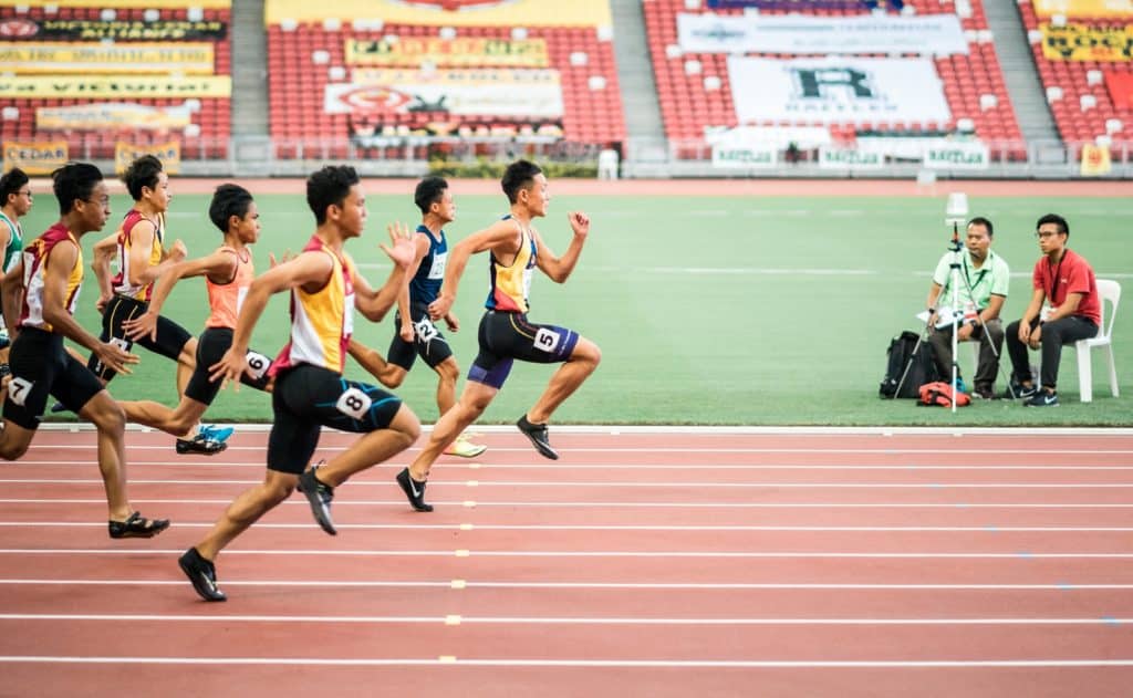 Gruppe von Männern, die im Leichtathletikfeld laufen