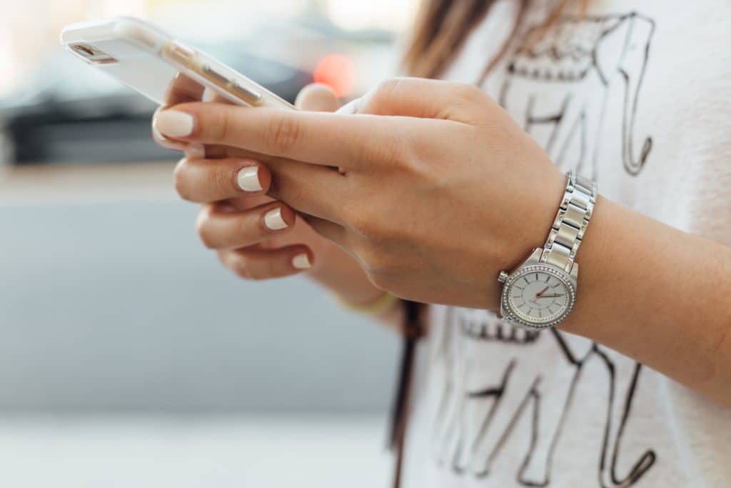 Frau hält iPhone bei Tageslicht