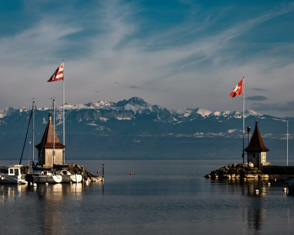 Braunes und weißes Boot auf dem Wasser in der Nähe des braunen Holzdocks bei Tag