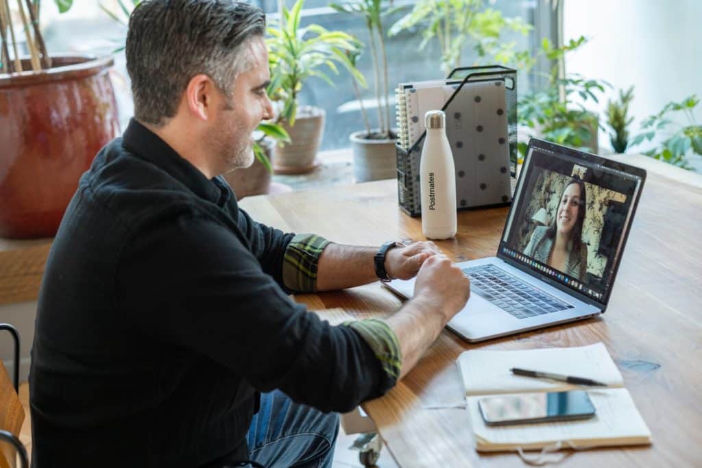 Mann in schwarzem Pullover mit Macbook Pro