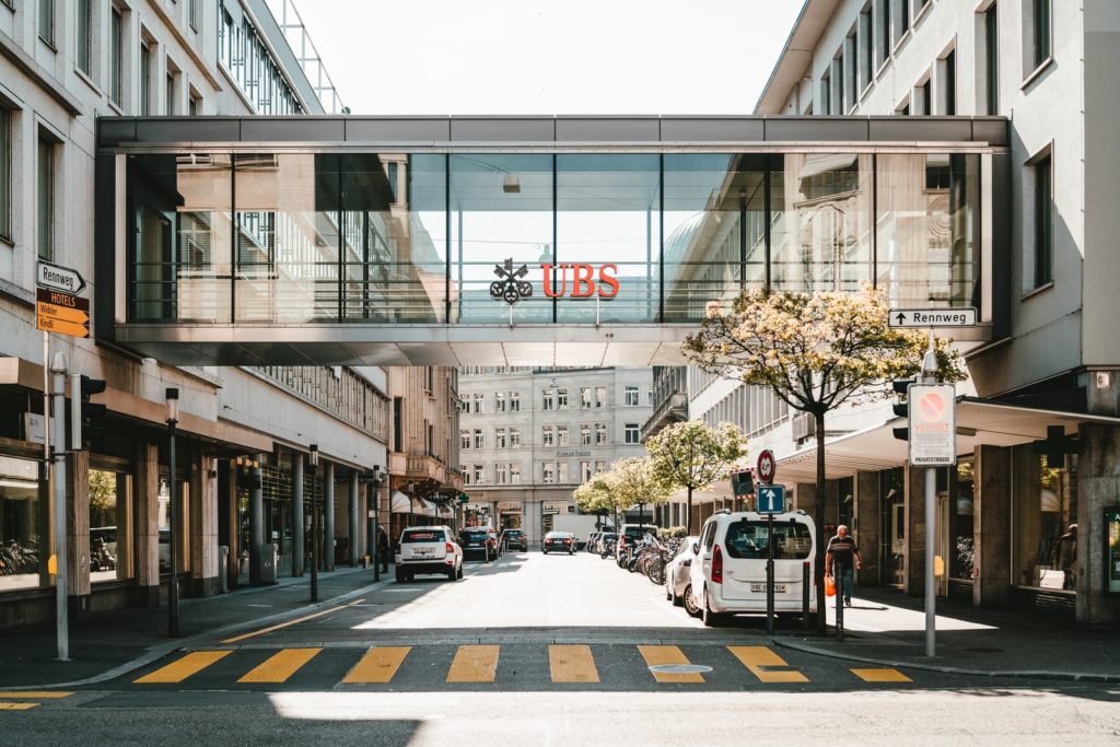 UBS-Logo auf der gläsernen Brückenwand bei Tag