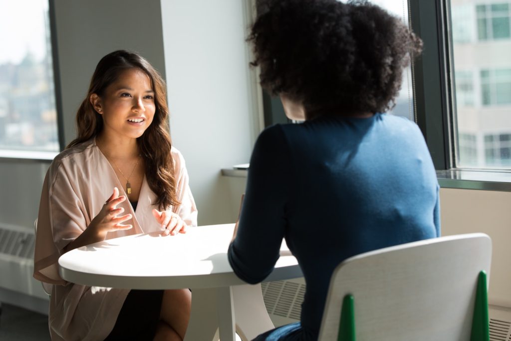 duas mulheres sentadas em uma cadeira