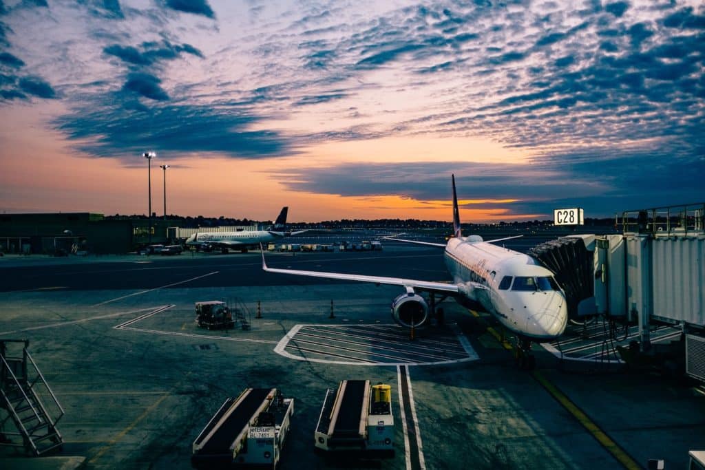 avión blanco cerca de remolques durante la puesta de sol