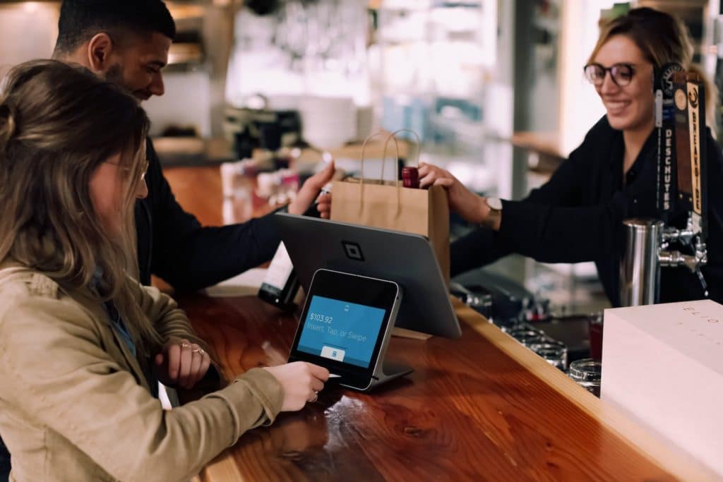 pessoas usando dispositivos em uma mesa marrom