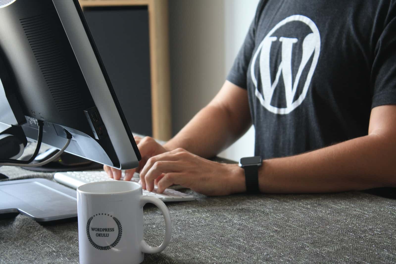 黒と白のTシャツを着てコンピュータを使う人