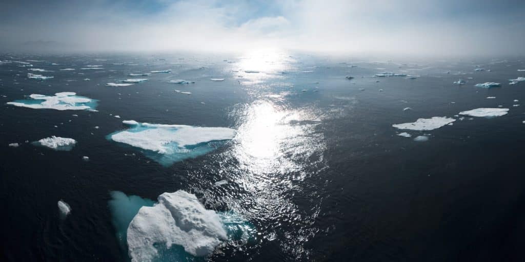 paisagem e fotografia aérea de icebergs em um corpo de água durante o dia