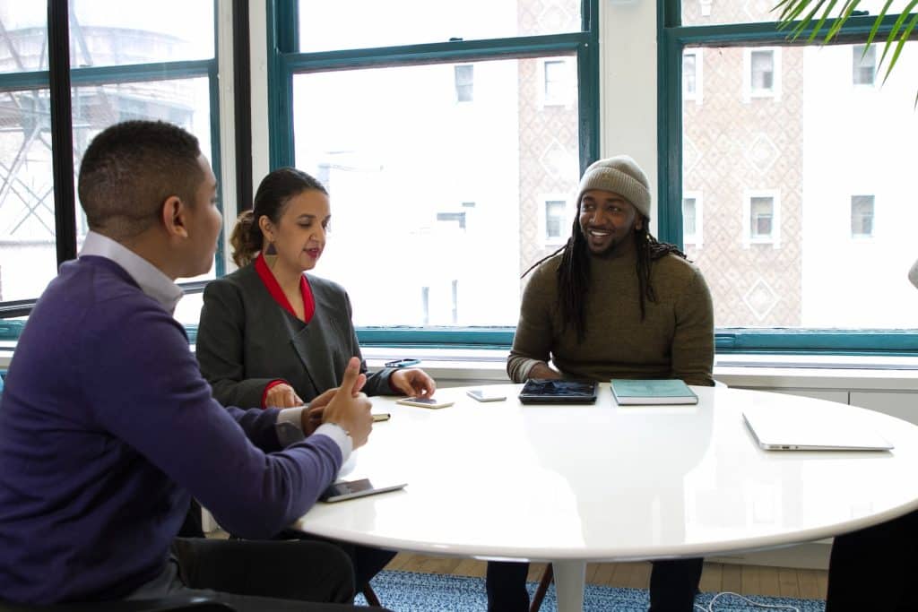 un groupe de personnes assises autour d'une table blanche